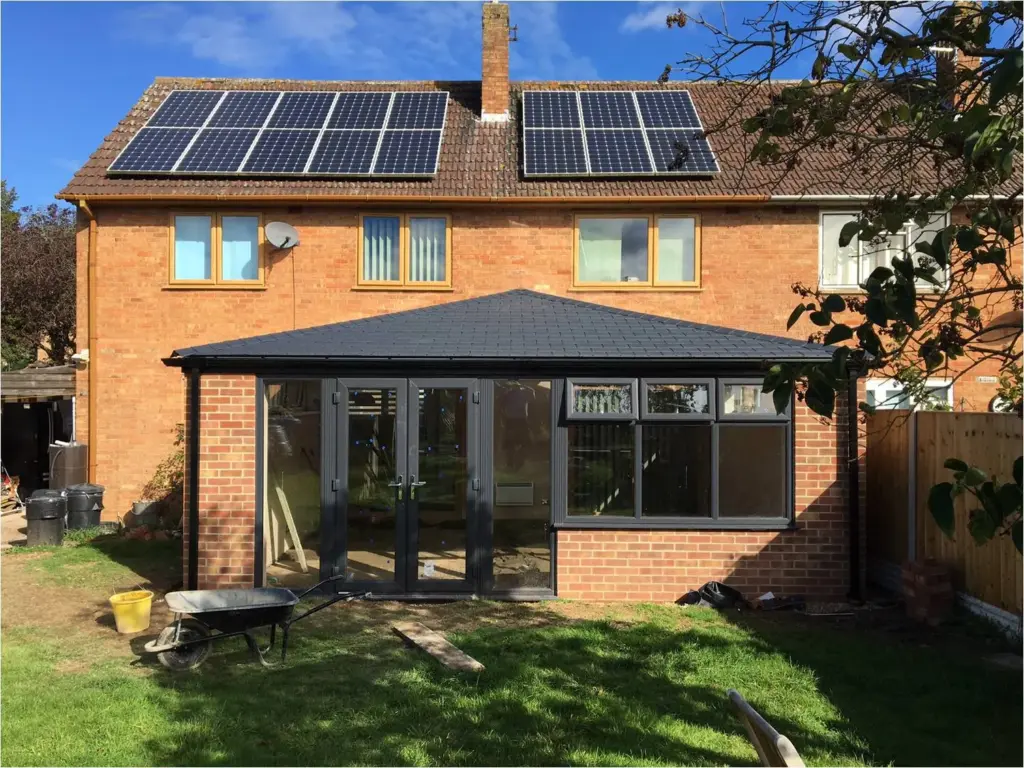 brown brick conservatory with black roof and window frames