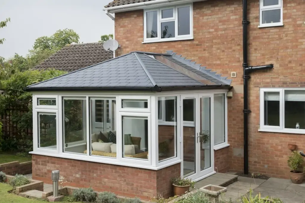 conservatory with black roof on red brick house external view